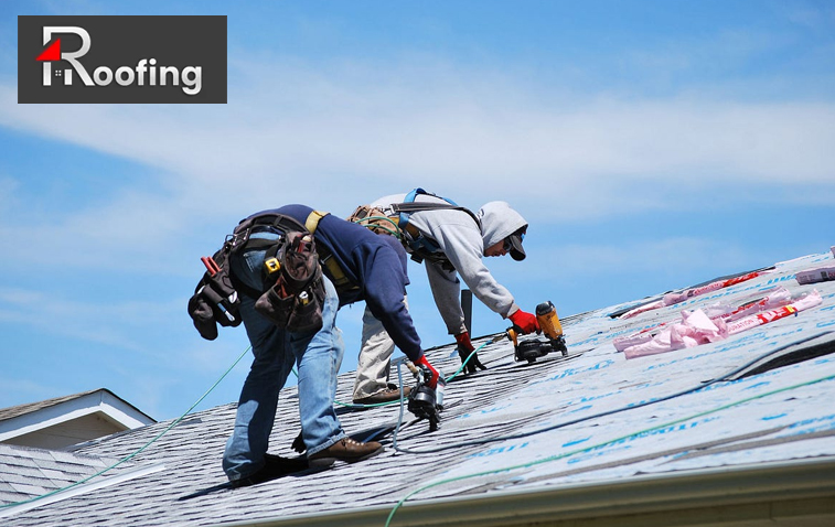 Workers from a commercial roofing contractor applying roofing materials